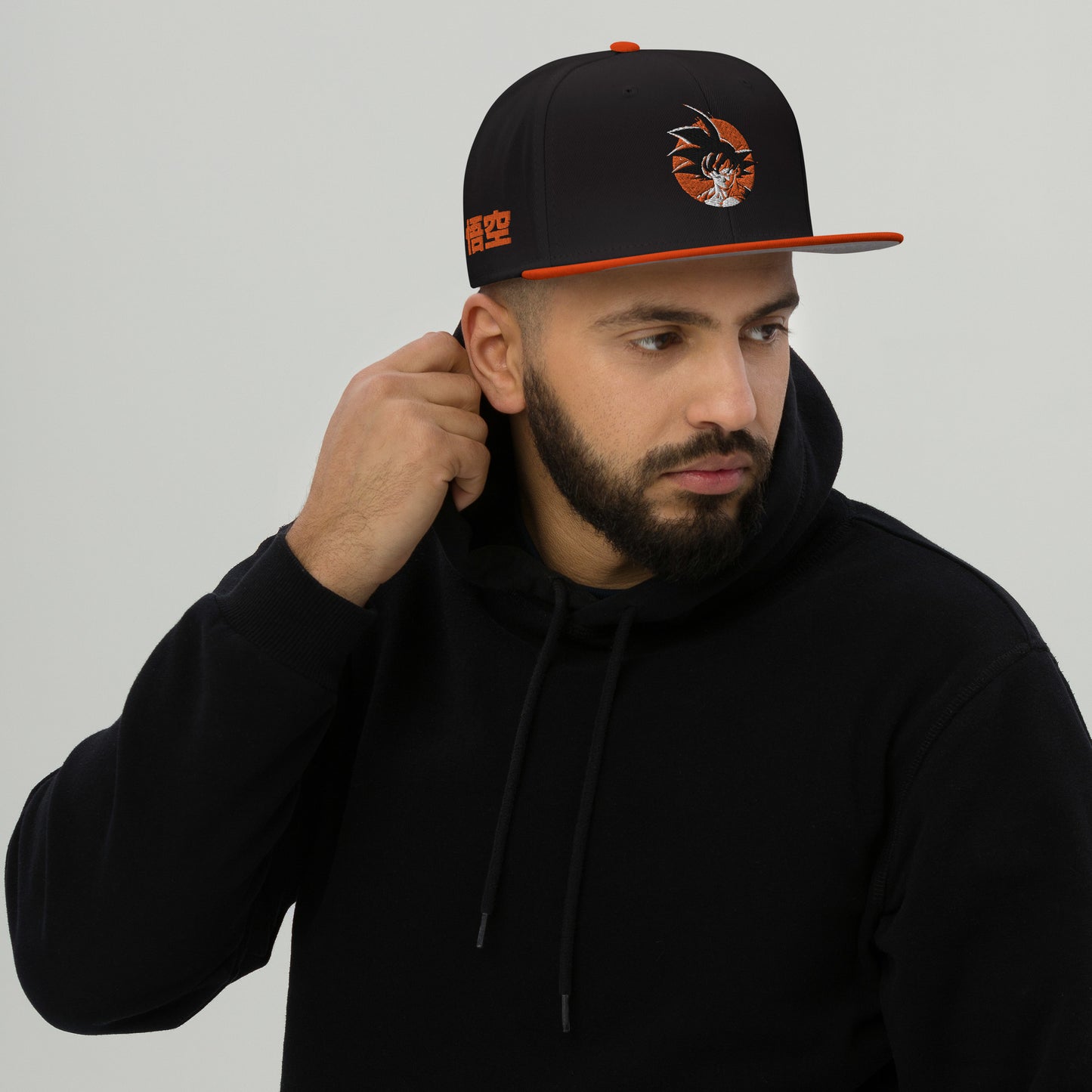  Lifestyle image of someone wearing the Goku Snapback Hat in an urban setting, highlighting its comfort and style for everyday wear. Male Model 